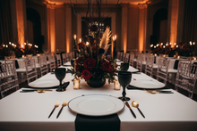 Load image into Gallery viewer, Dramatic tablescape with Marie A black-rimmed charger, black Monet glassware, and black-gold flatware
