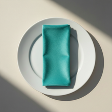 Load image into Gallery viewer, Turquoise velvet napkin arranged on a plain white plate

